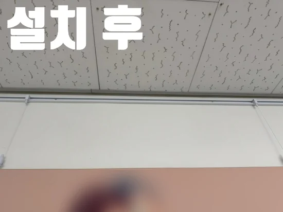 설치 후 문구와 함께 콘크리트 벽 상부 레일에 캔버스를 건 모습