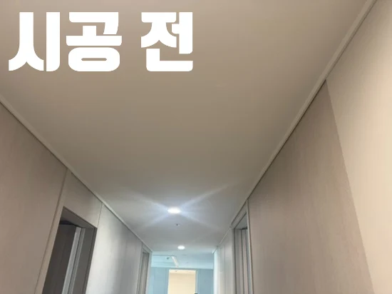 시공 전 문구와 함께 액자를 걸기 전 비어 있는 복도 벽
