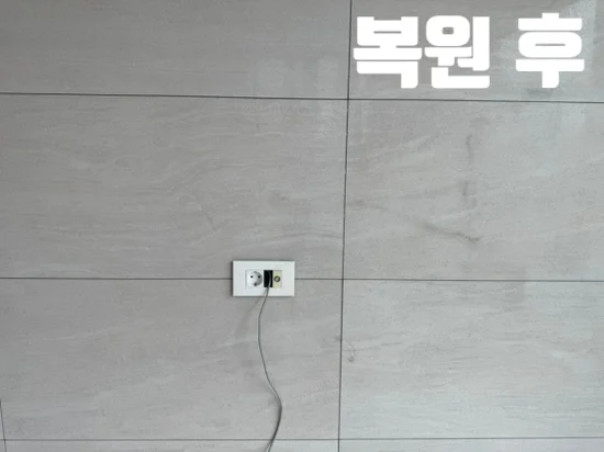 복원 후 벽걸이 TV 구멍을 메우고 주변 무늬에 맞춰 정리한 회색 아트월