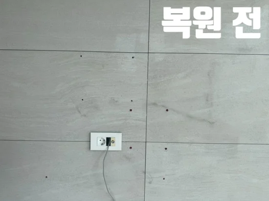 복원 전 벽걸이 TV 브라켓을 철거한 회색 아트월에 남은 구멍 10곳