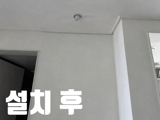 설치 후 문구와 함께 문 시작선에 맞춘 짧은 노출형 액자레일을 보여주는 모습