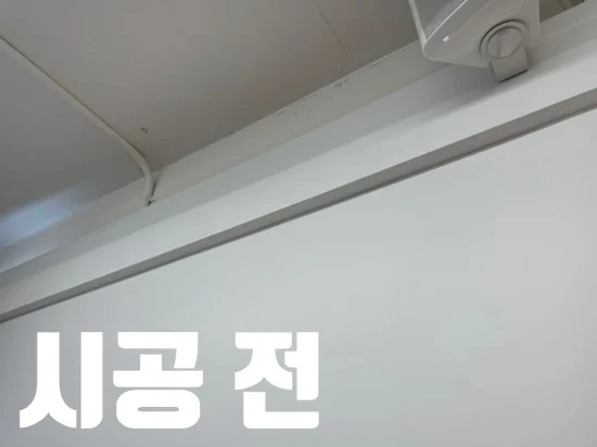 시공 전 문구와 함께 거울을 설치할 미용실 벽 마감을 보여주는 모습