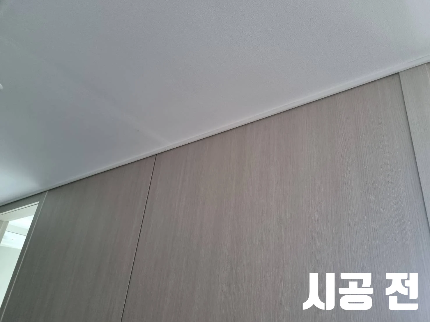 시공 전 문구와 함께 웨딩사진을 걸기 전 아트월을 보여주는 모습