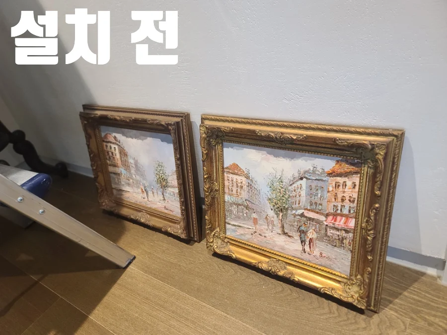 설치 전 문구와 함께 바닥에 놓인 클래식 그림 두 점을 보여주는 모습